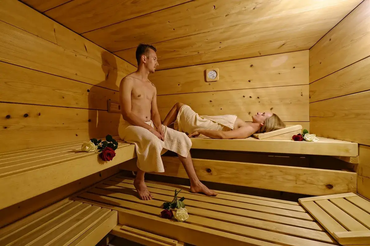 Ein Paar entspannt sich in einer Sauna. Vielleicht ist dies ein Teil eines **Bauernhofs in den Bergen**, wo man nach einem aktiven Tag in der Natur zur Ruhe kommen kann.