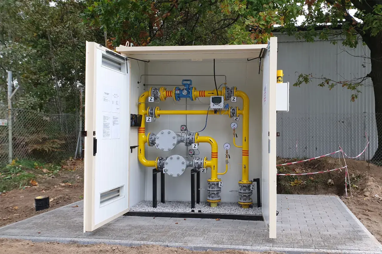 Nowe instalacje gazowe w Górze Kalwarii. Żółte rury, zawory i manometry w obudowie.