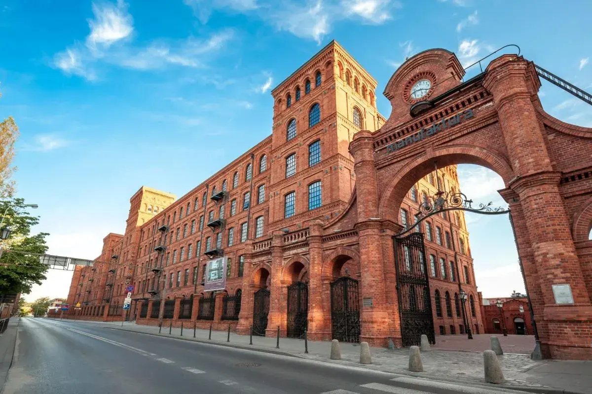 Imponująca ceglana Manufaktura w Łodzi, dawniej fabryka, dziś centrum kultury i rozrywki. Stare miasto tętni życiem.