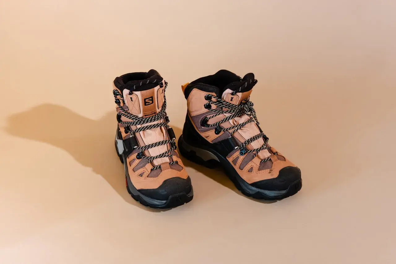 A pair of tan Salomon hiking boots with black accents and laces. These boots are designed for rugged terrain, but how much do hiking boots weigh?