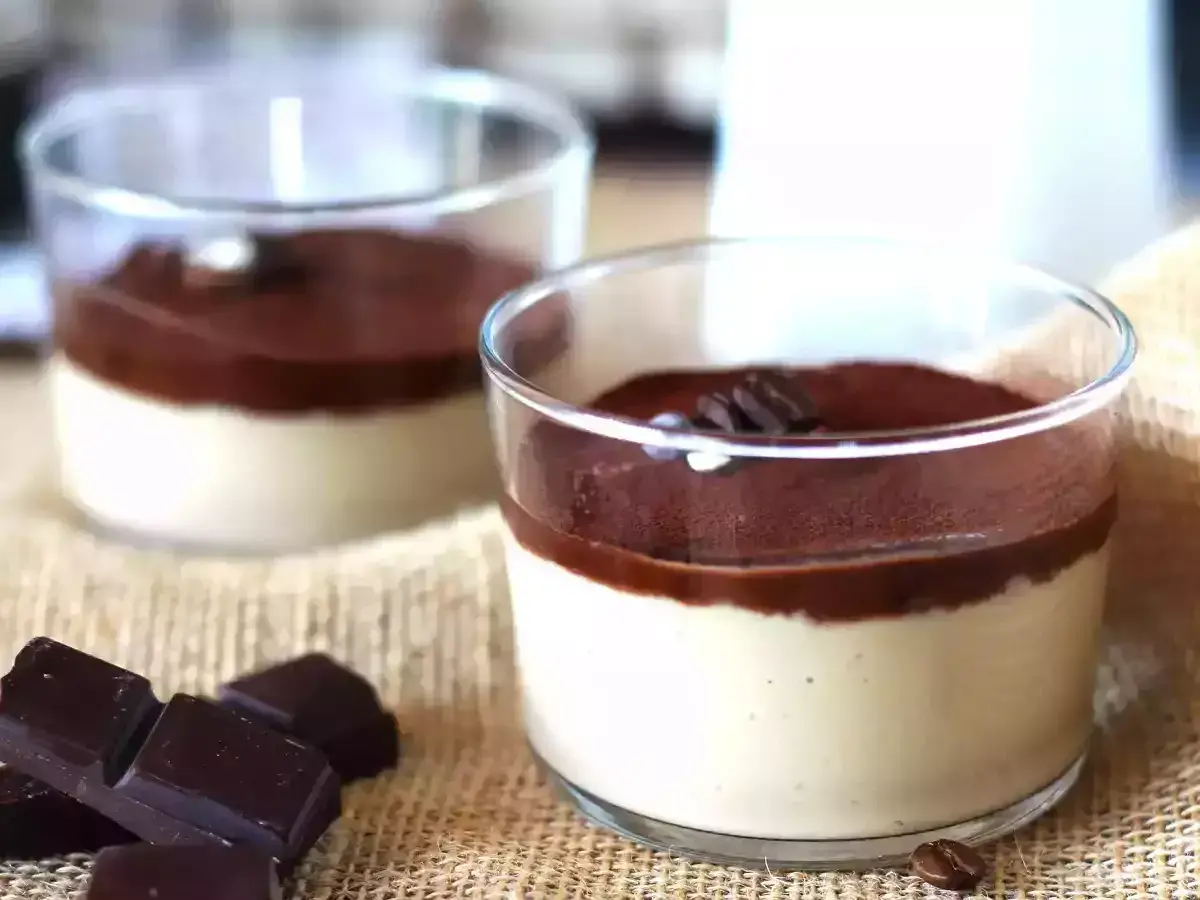 Deliziosa ganache al caffè espresso in bicchierini, guarnita con cacao e chicchi di caffè. Accanto, pezzi di cioccolato fondente.
