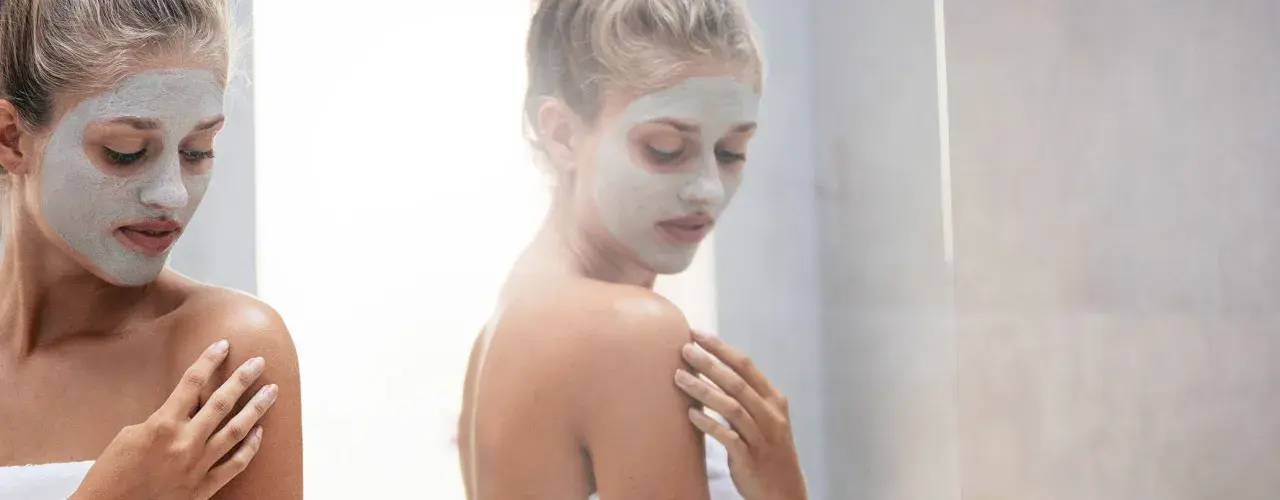 Donna con maschera viso, un rituale di bellezza prima o dopo la doccia per una pelle radiosa.