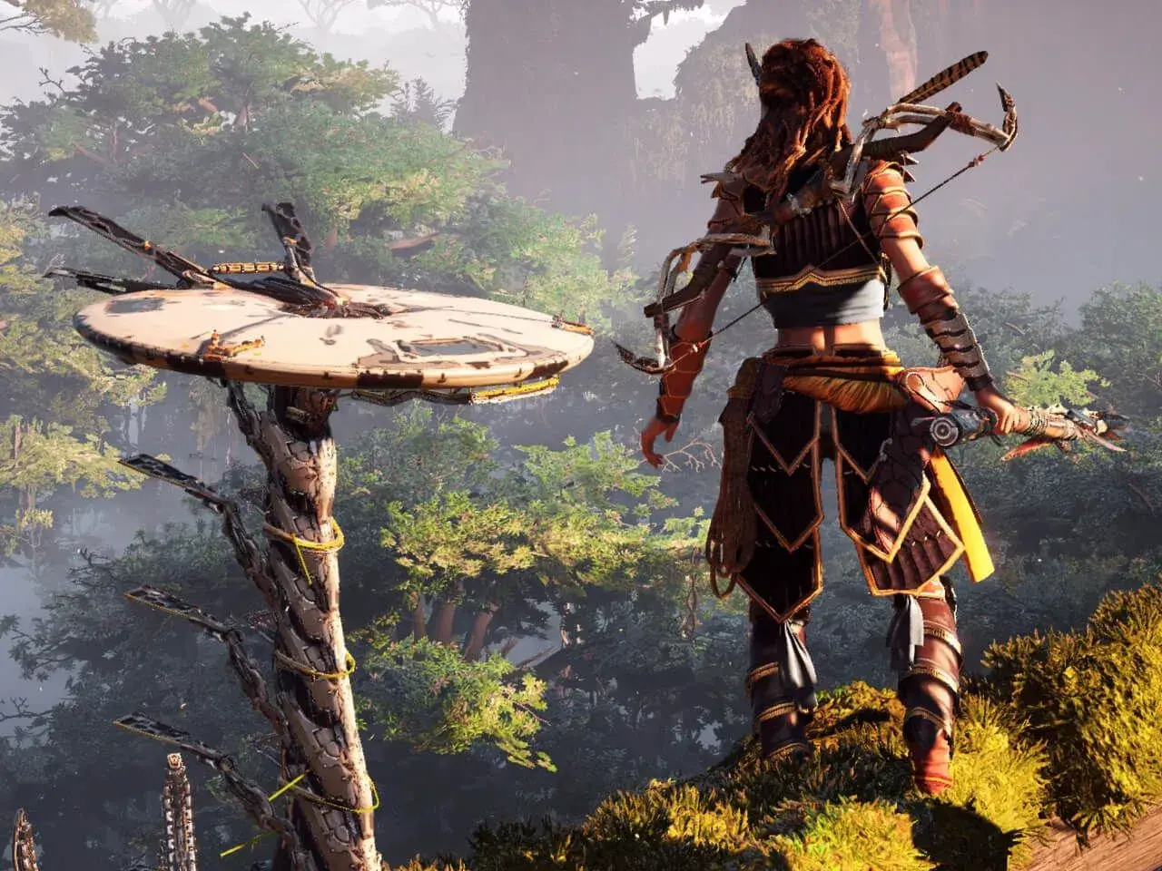 Aloy z łukiem stoi na wzgórzu, patrząc na maszynę w lesie. To kluczowy moment w Horizon Zero Dawn poradnik.