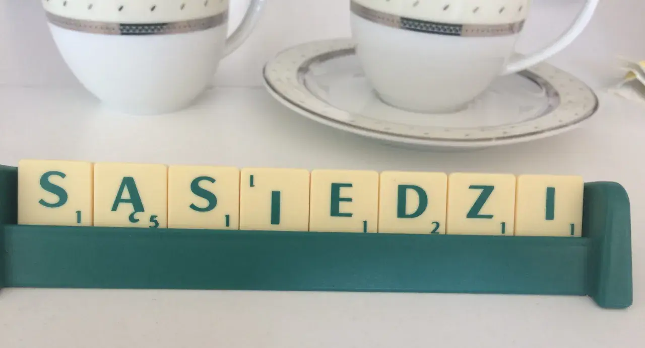 Litery z gry planszowej układają się w napis "SĄSIEDZI". Może to być art. 107 zakłócanie spokoju, gdy sąsiad jest głośny.