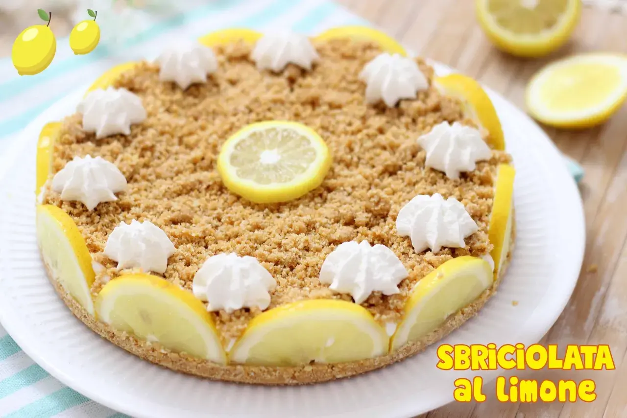 Deliziosa sbriciolata al limone senza cottura, decorata con fettine di limone e ciuffetti di panna. Perfetta per un dessert fresco e goloso.