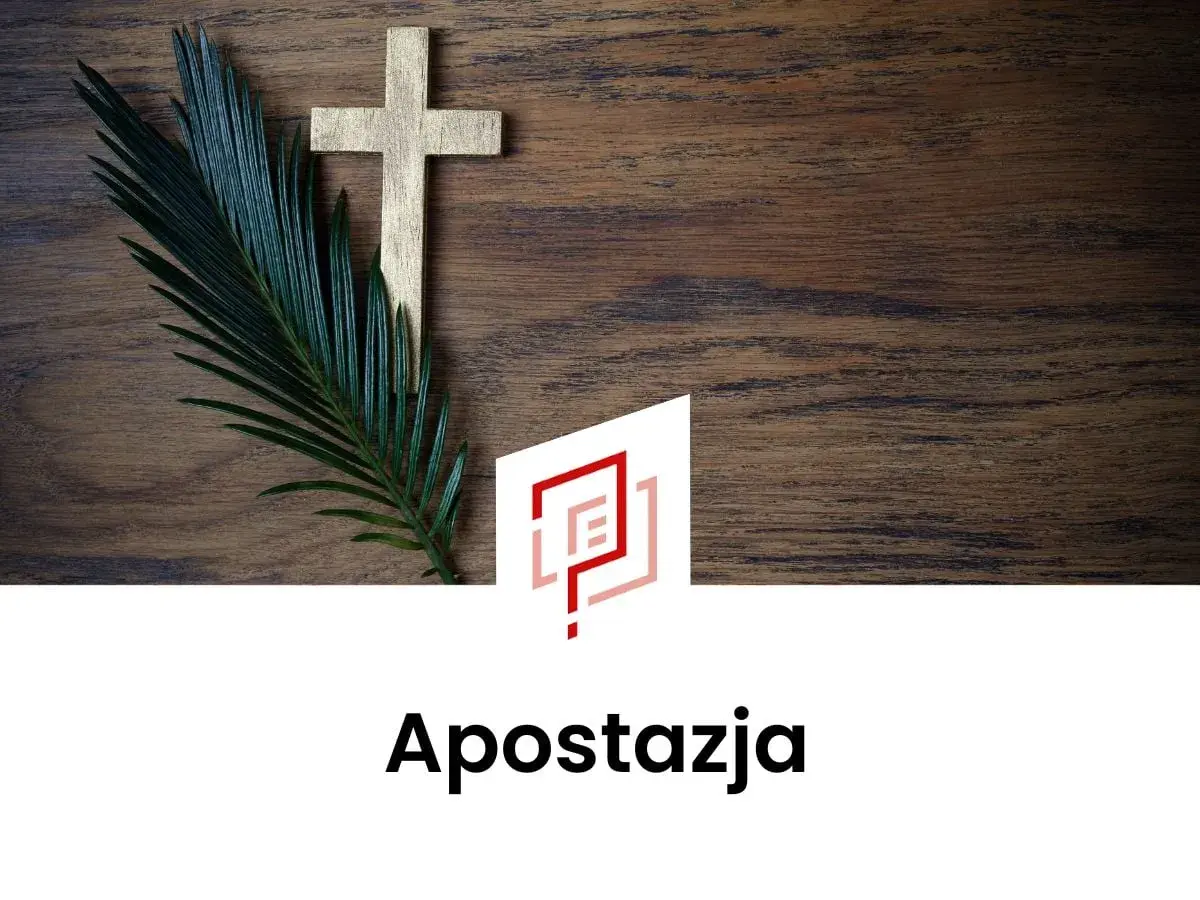 Złoty krzyż i gałązka palmy na drewnianym tle. Co to apostazja?