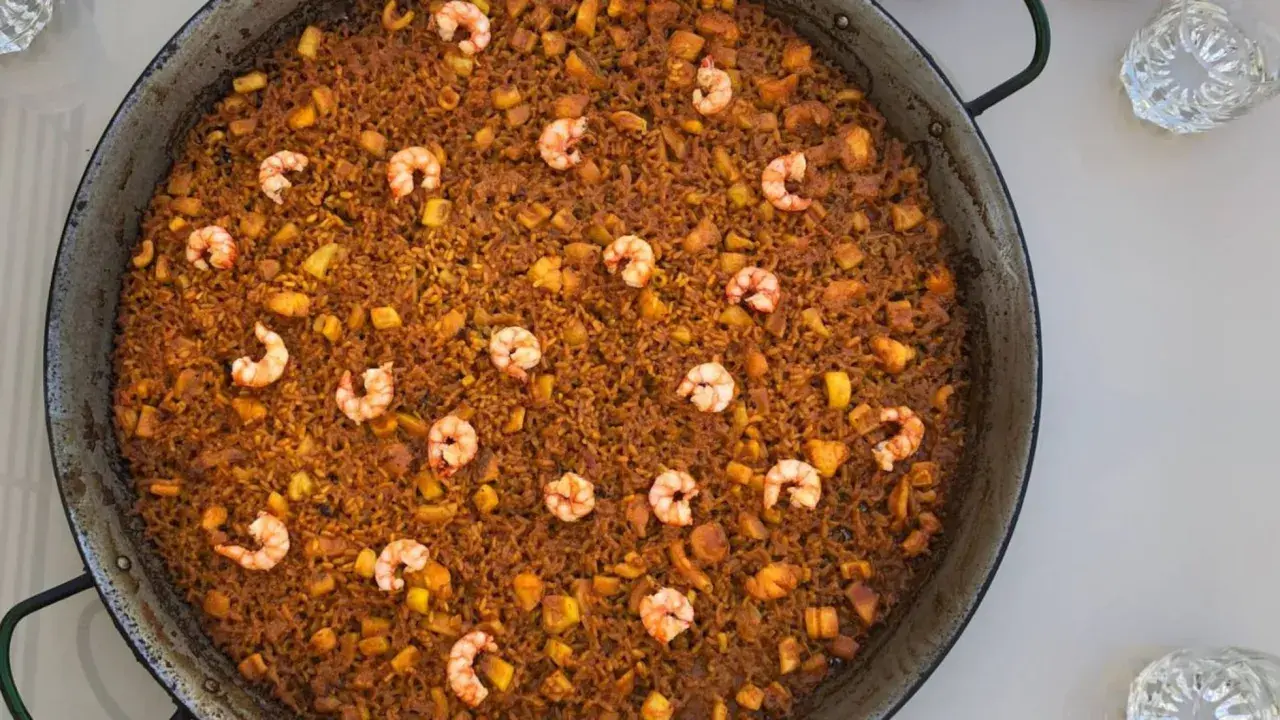 Arroz del senyoret en paellera, con gambas, trozos de calamar y patata. Un plato generoso y lleno de sabor.