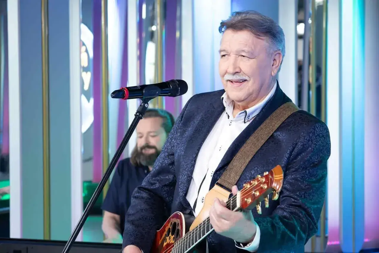 Andrzej Rybiński śpiewa "Nie liczę godzin i lat", grając na gitarze.