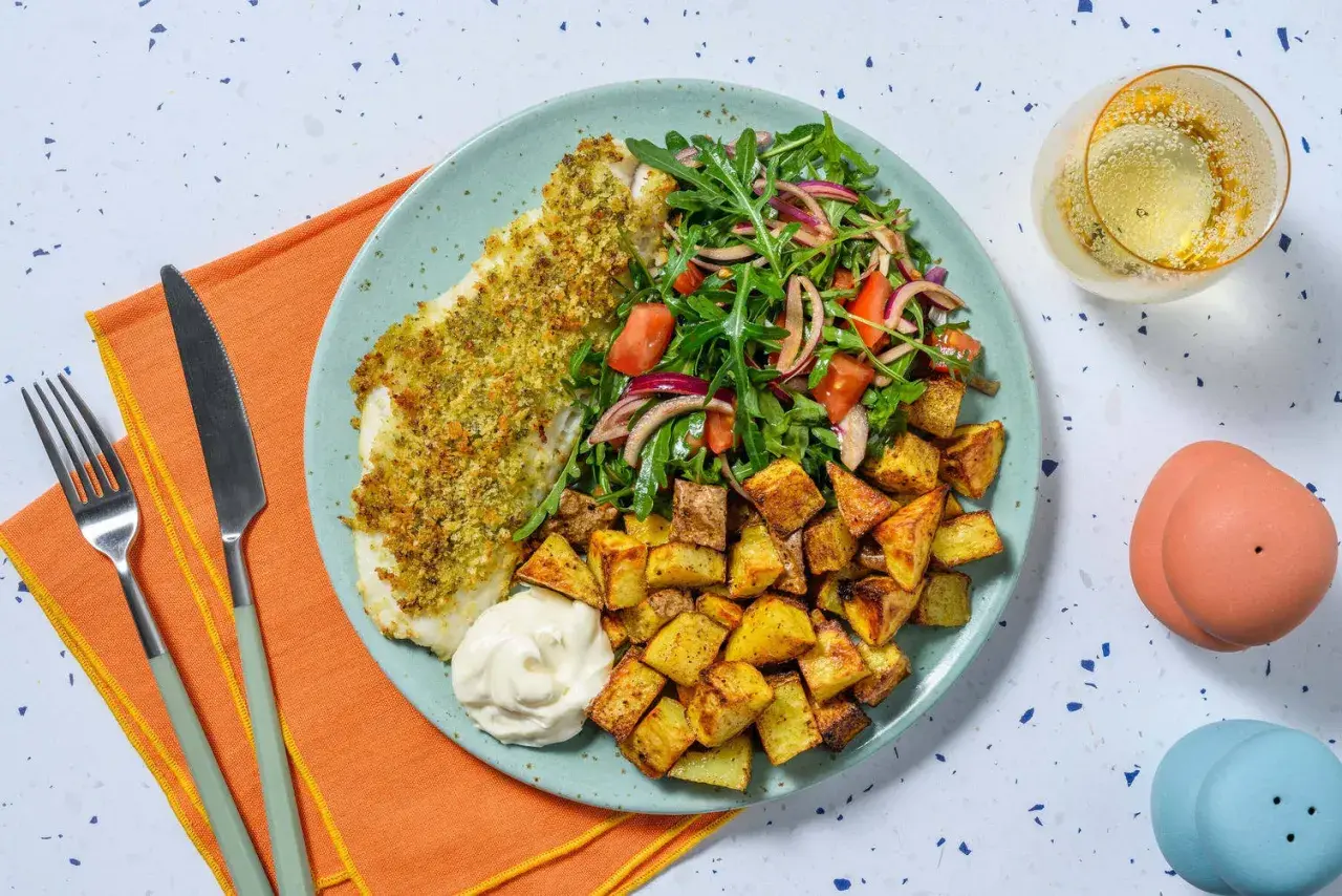 En tallrik med panerad torsk, krispiga potatisbitar, en fräsch sallad och en klick majonnäs. Ett perfekt torsk recept för en god middag.