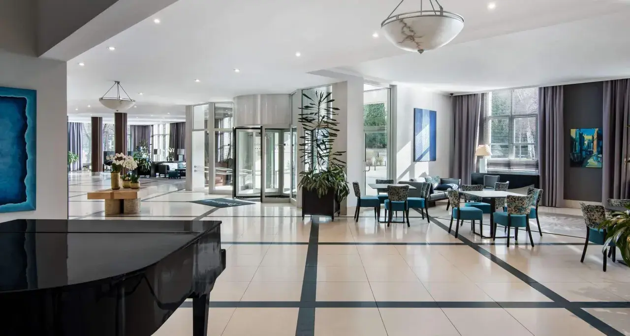 Eleganckie wnętrze hotelu Radisson Blu Wrocław z fortepianem, wygodnymi fotelami i stolikami.