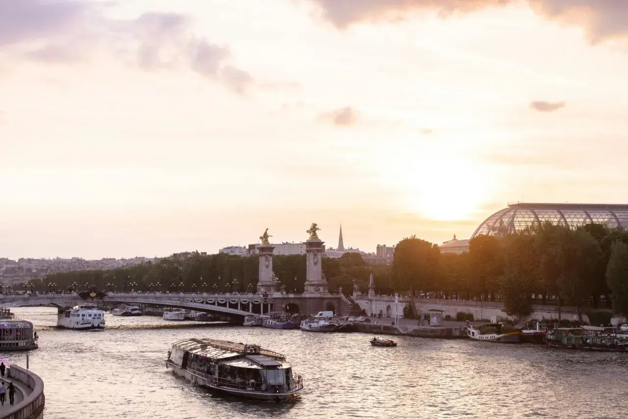 Boote auf der Seine bei Sonnenuntergang, eine malerische Szene, die die beste Reisezeit Paris widerspiegelt.
