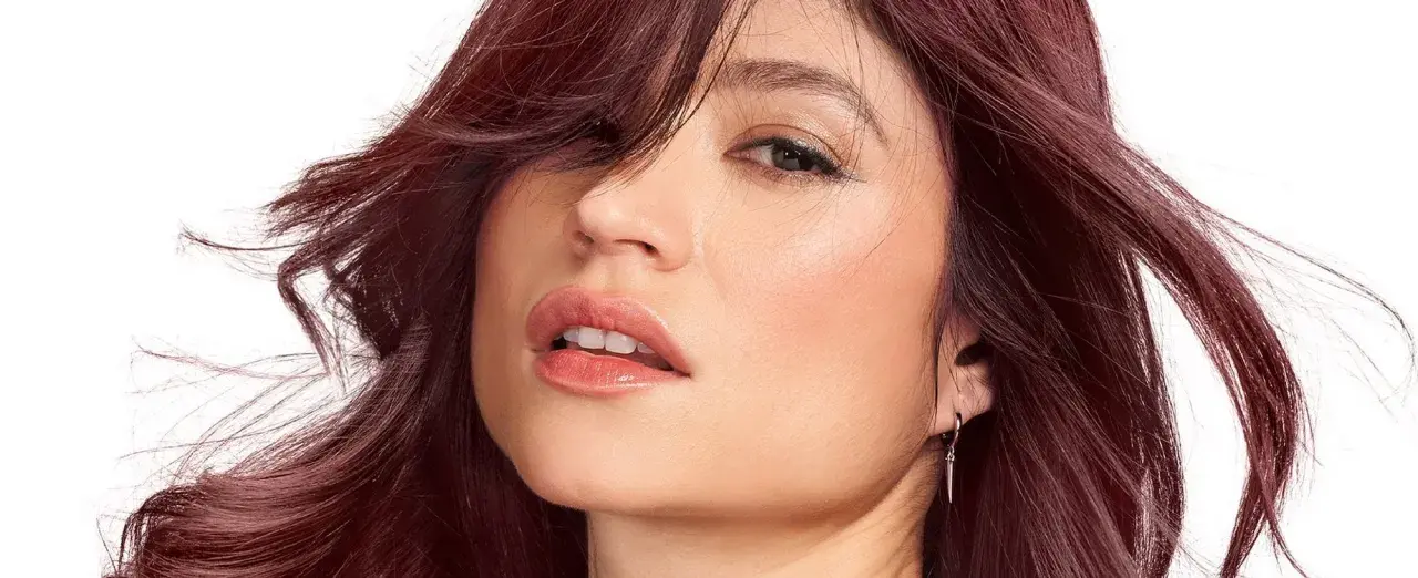 Mujer con un vibrante **cherry pelo** que enmarca su rostro, con labios jugosos y una mirada cautivadora.