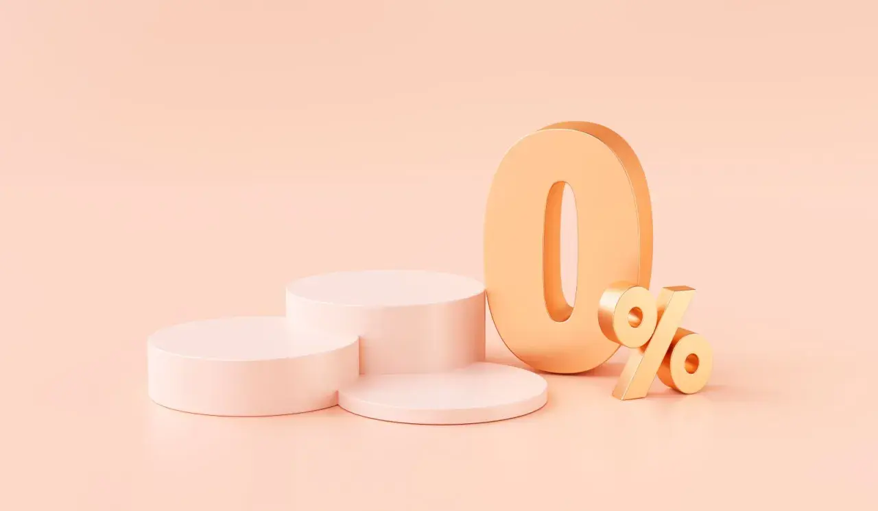 Złote cyfry "0%" na pastelowym tle, obok okrągłych podium. Idealna oferta na raty 0%.