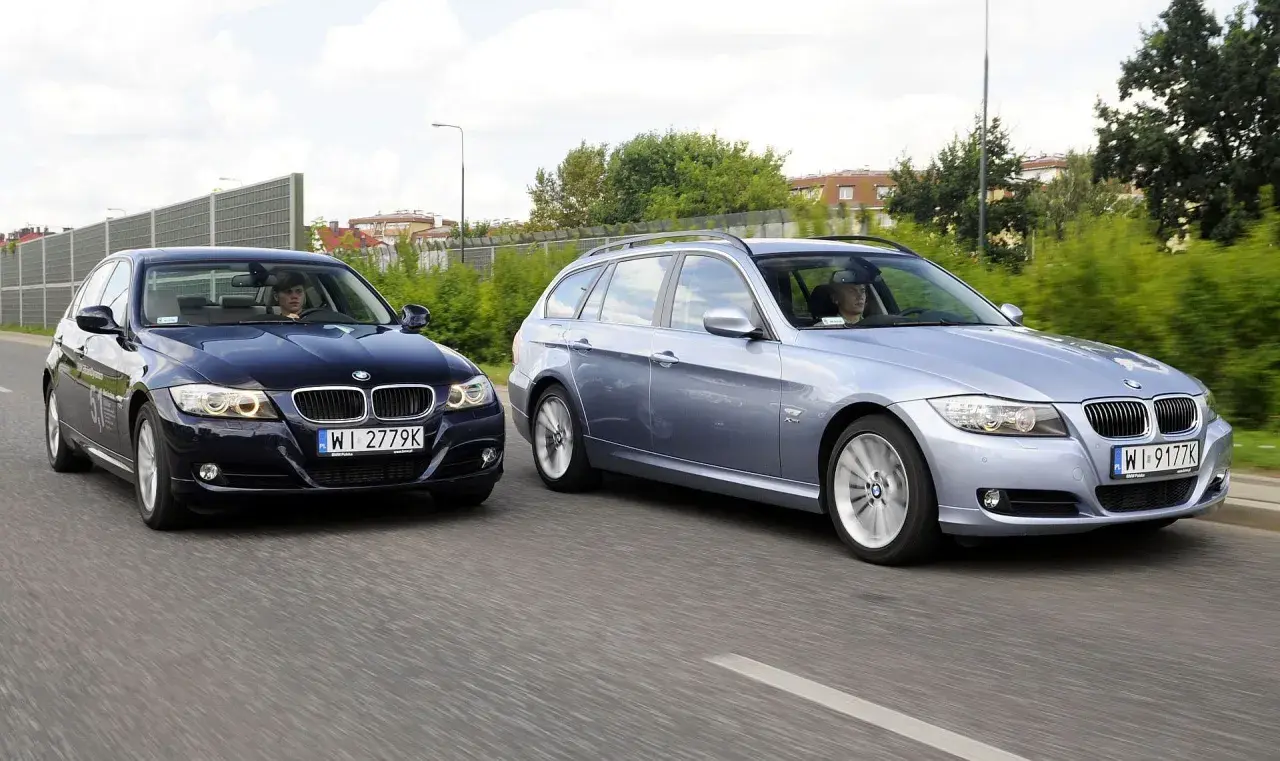 Dwa BMW E90 2.0 benzyna jadące obok siebie. Jeden to ciemny sedan, drugi to jasny kombi.