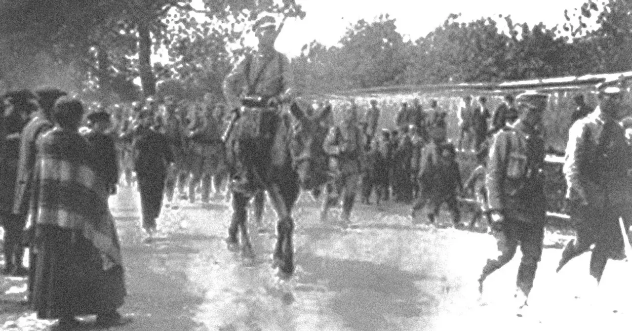 Żołnierze w historycznych mundurach, w tym na koniu, maszerują w zwartym szyku. To widok nawiązujący do czasów, gdy formowały się legiony polskie.