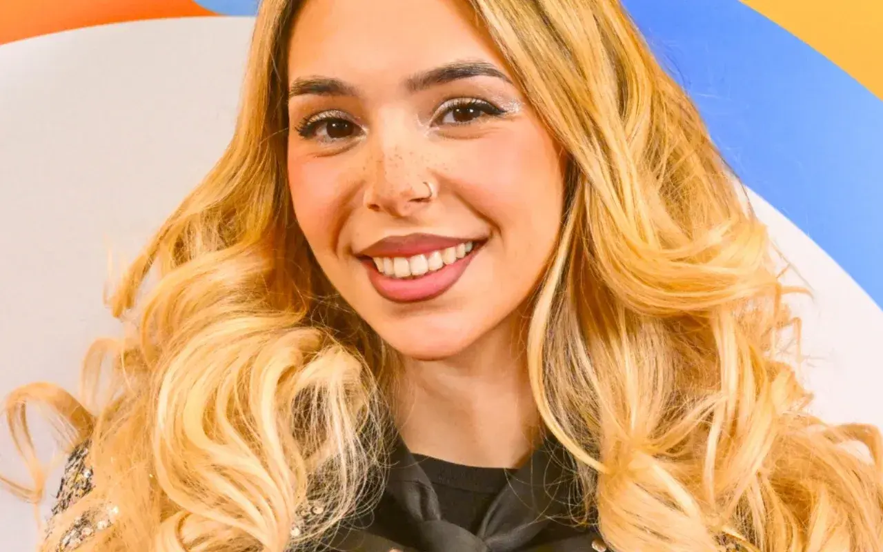 Uśmiechnięta młoda kobieta z blond włosami i piegami.