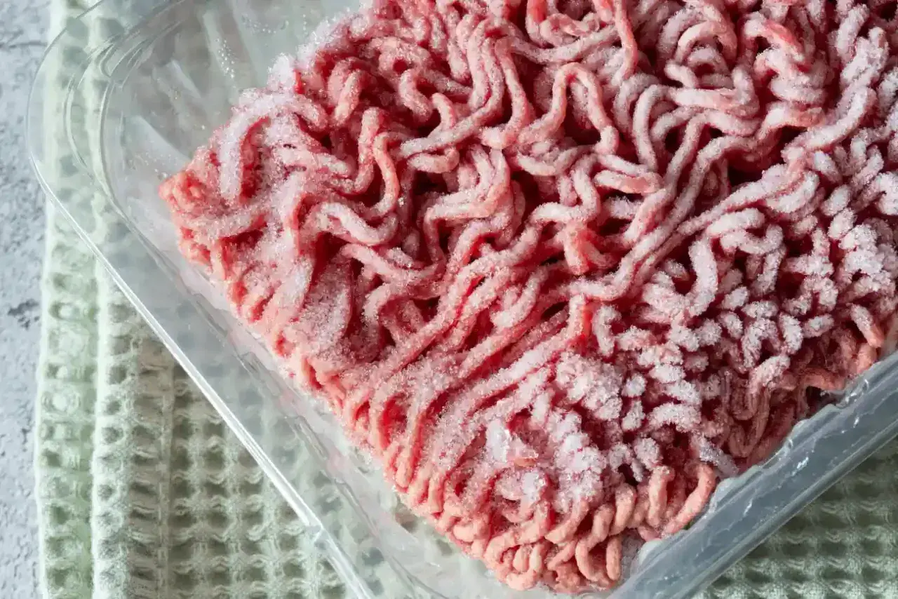 Mrożone mięso mielone w plastikowym opakowaniu, gotowe do rozmrożenia w mikrofali.