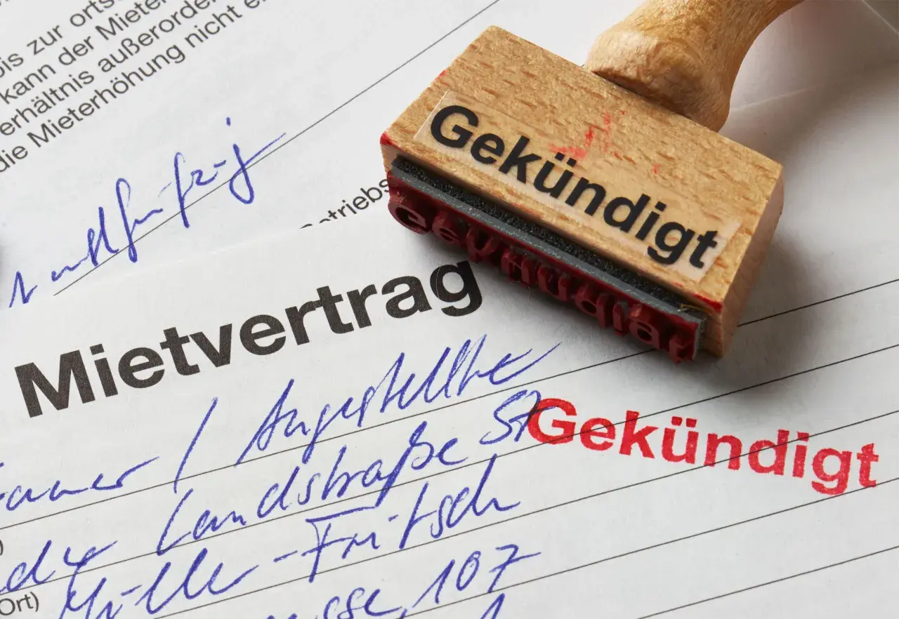 Mietvertrag mit Stempel "Gekündigt". Einer der Mieter zieht aus.