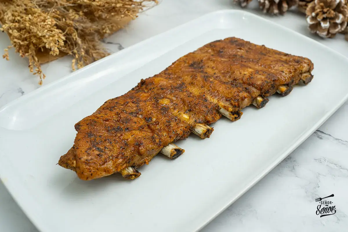 Costilla de cerdo al horno, jugosa y dorada, lista para disfrutar. Un manjar que invita a saborear cada bocado.