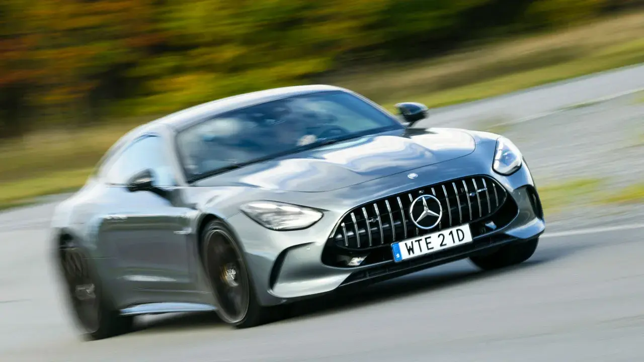 Grå Mercedes AMG GT accelererar på en väg. Lär dig hur startar man en manuell bil och njut av körglädjen.