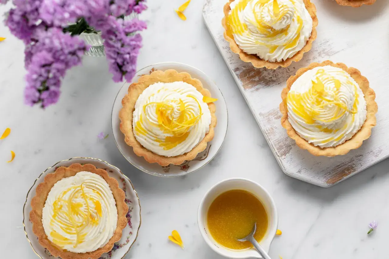 Deliziosi tartellette con crema bianca e scorzette di limone, un tocco di cioccolato al limone per un sapore unico.