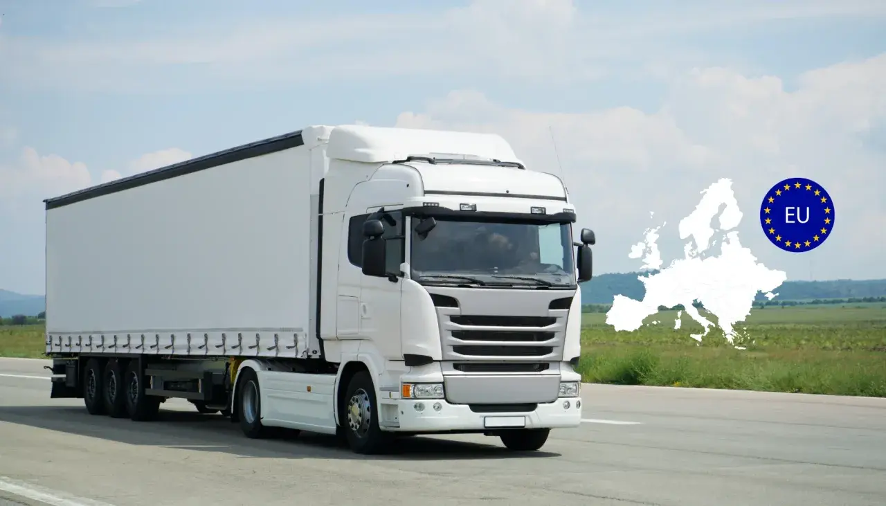 Un camion blanc, d'une hauteur d'un poid lourd, roule sur une route. L'Europe et le drapeau de l'UE sont superposés en arrière-plan.