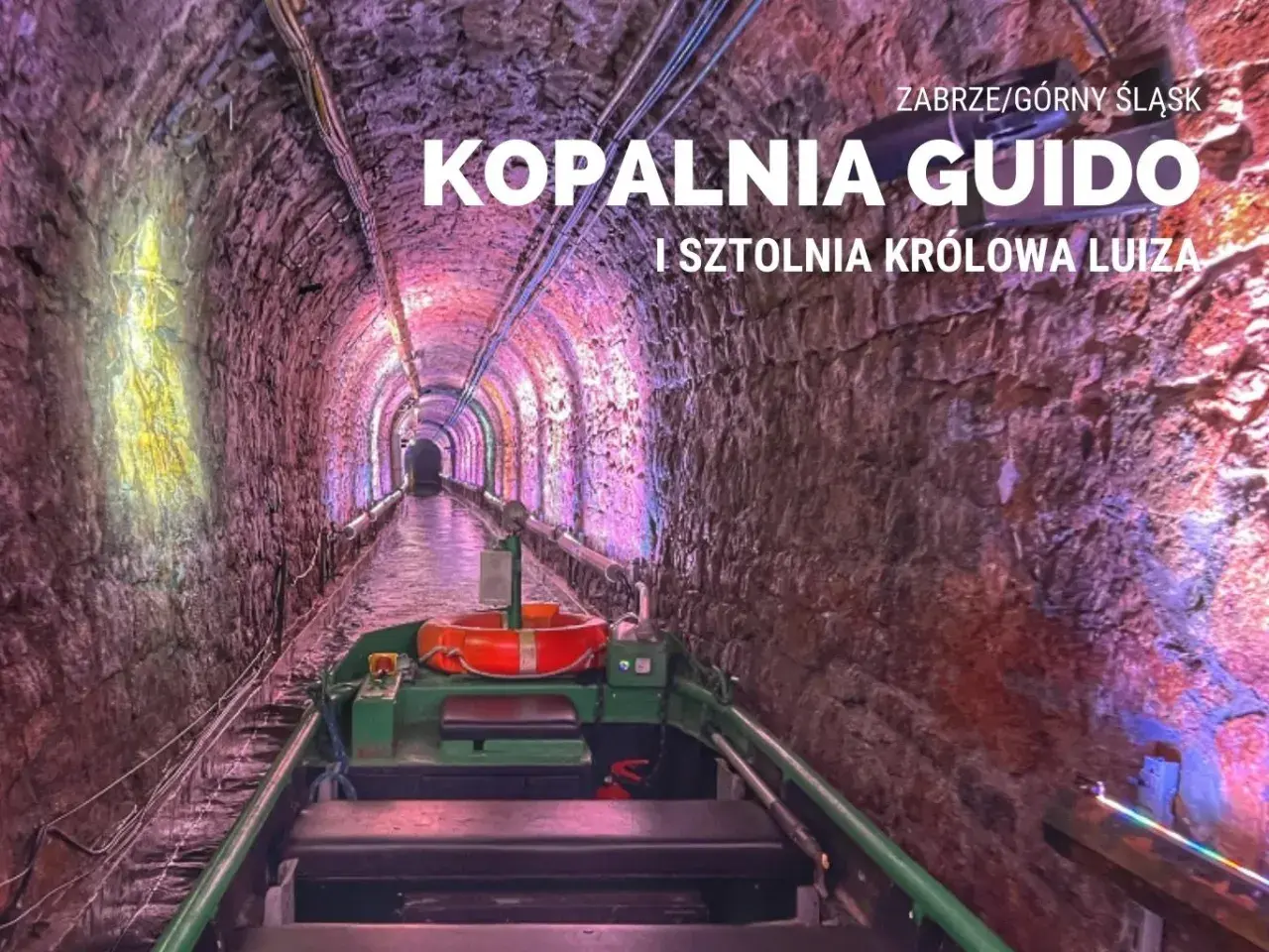 Podziemny spływ w kopalni Guido. Łódź płynie przez oświetlony tunel z kamiennymi ścianami.