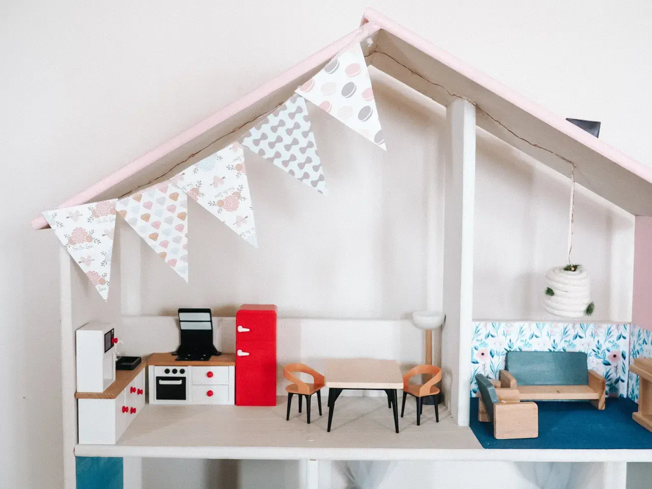 Urocze meble dla lalek diy: kuchnia z lodówką, stół z krzesłami i salon z kanapą.