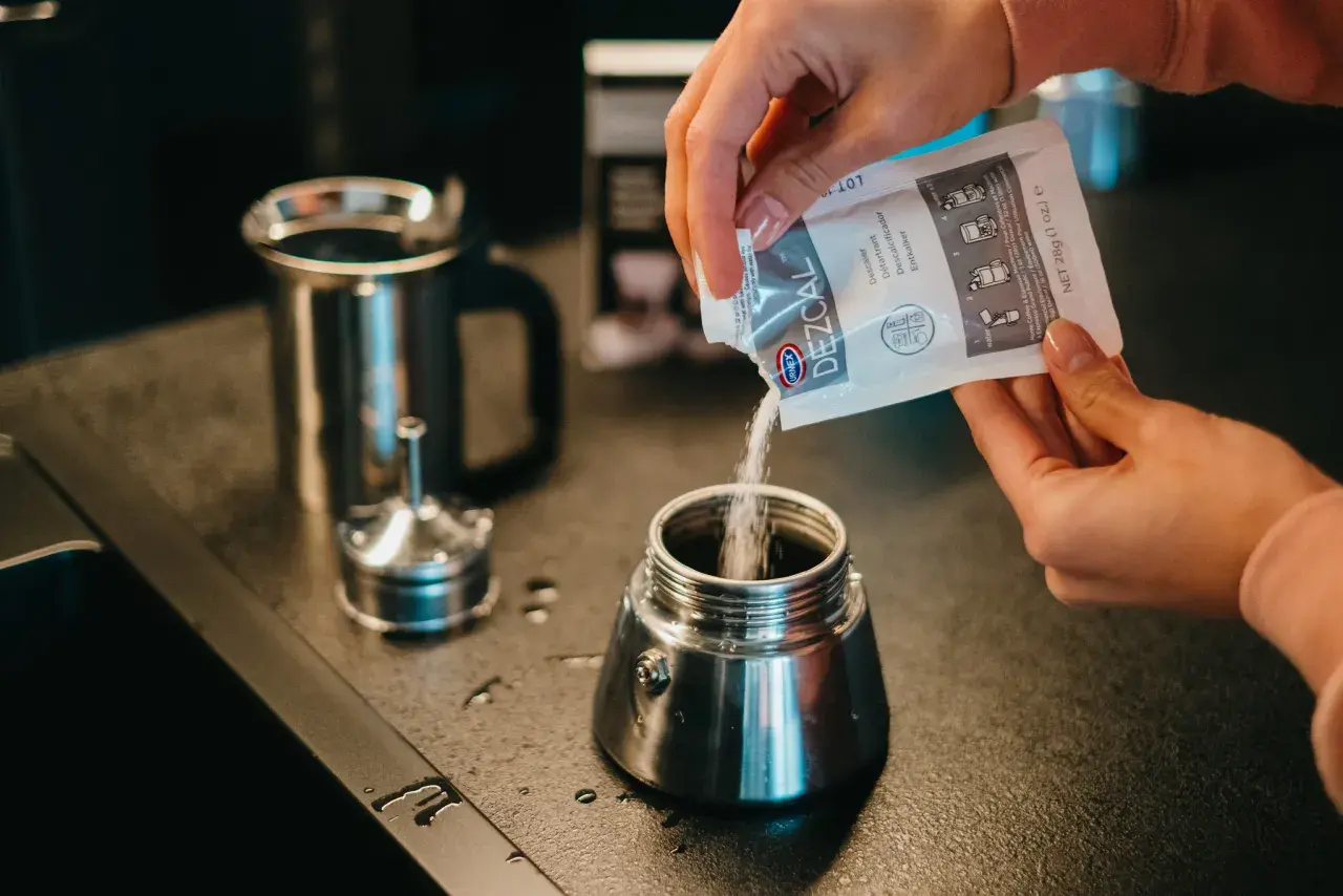 Wsypywanie proszku do czyszczenia kawiarki. Czyszczenie kawiarki sodą to świetny sposób na jej odświeżenie.