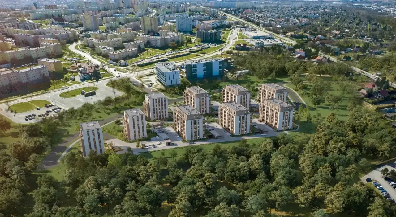 Nowe inwestycje w Kielcach: nowoczesne bloki mieszkalne otoczone zielenią, w tle widoczne osiedla i droga.