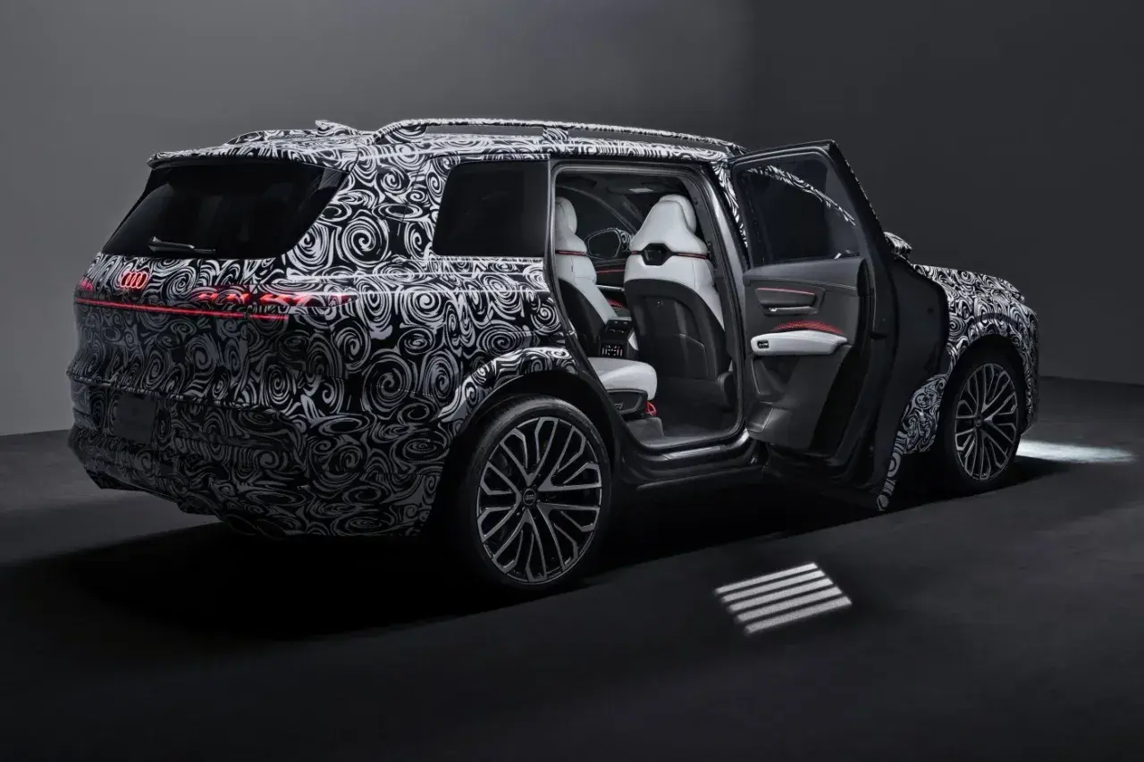Nowy Audi Q9 w kamuflażu, z otwartymi drzwiami, prezentuje luksusowe wnętrze. Czekamy na jego cenę i premierę!
