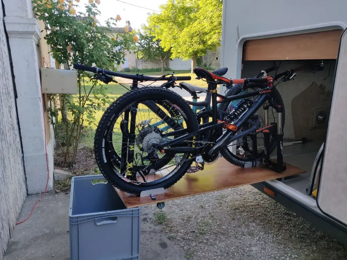 Plateforme DIY pour fabriquer un porte vélo de soute, avec deux VTT prêts à être rangés.