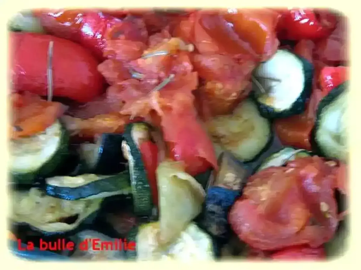 Un plat coloré de ratatouille au four, avec des rondelles de courgettes, des poivrons rouges et des tomates. Un délice provençal !