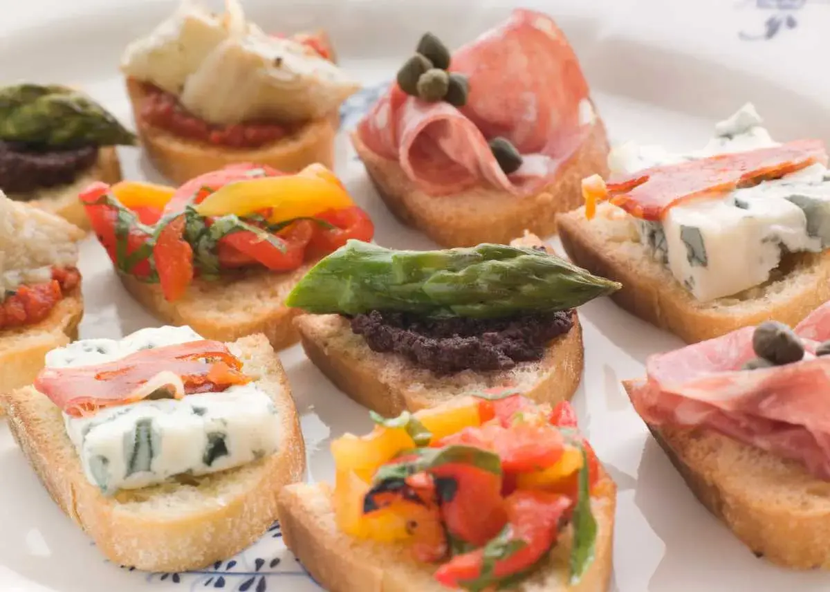 Variedad de crostini italiano: con salami, queso azul, espárragos, tomates y aceitunas.