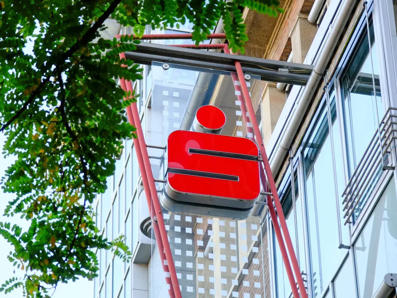 Rotes Sparkassen-Logo an einem Gebäude. Die Frage "wie lange bucht die Sparkasse" wird hier nicht beantwortet, aber das Logo ist gut sichtbar.