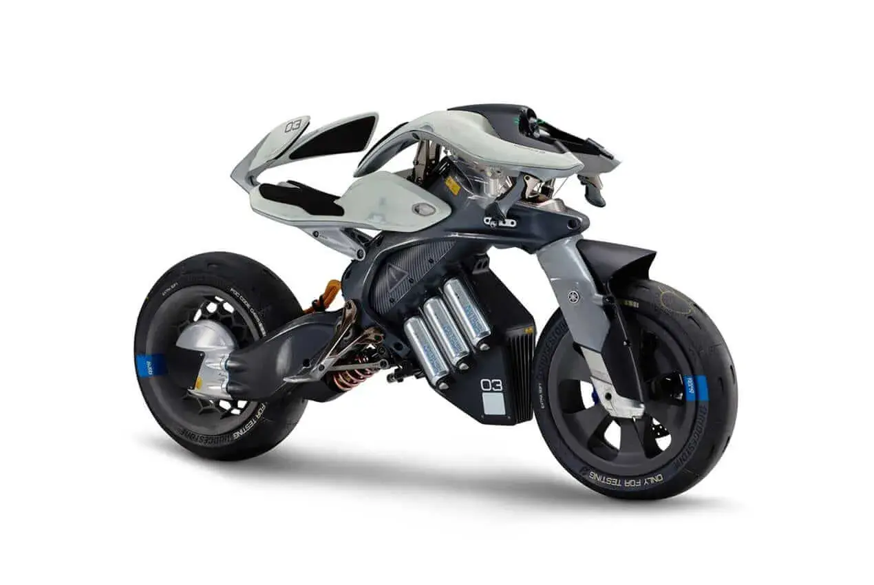 Futurystyczny motocykl Yamaha, z widocznymi ogniwami baterii, prezentuje innowacyjny design. Jego kraj pochodzenia to Japonia.