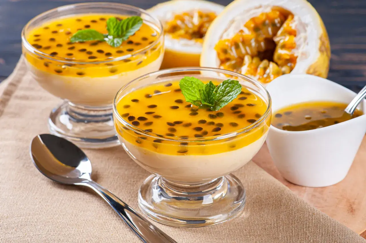 Douceur tropicale : deux coupes de mousse onctueuse, garnies de fruits de la passion et de menthe, un délice de dessert brésilien.