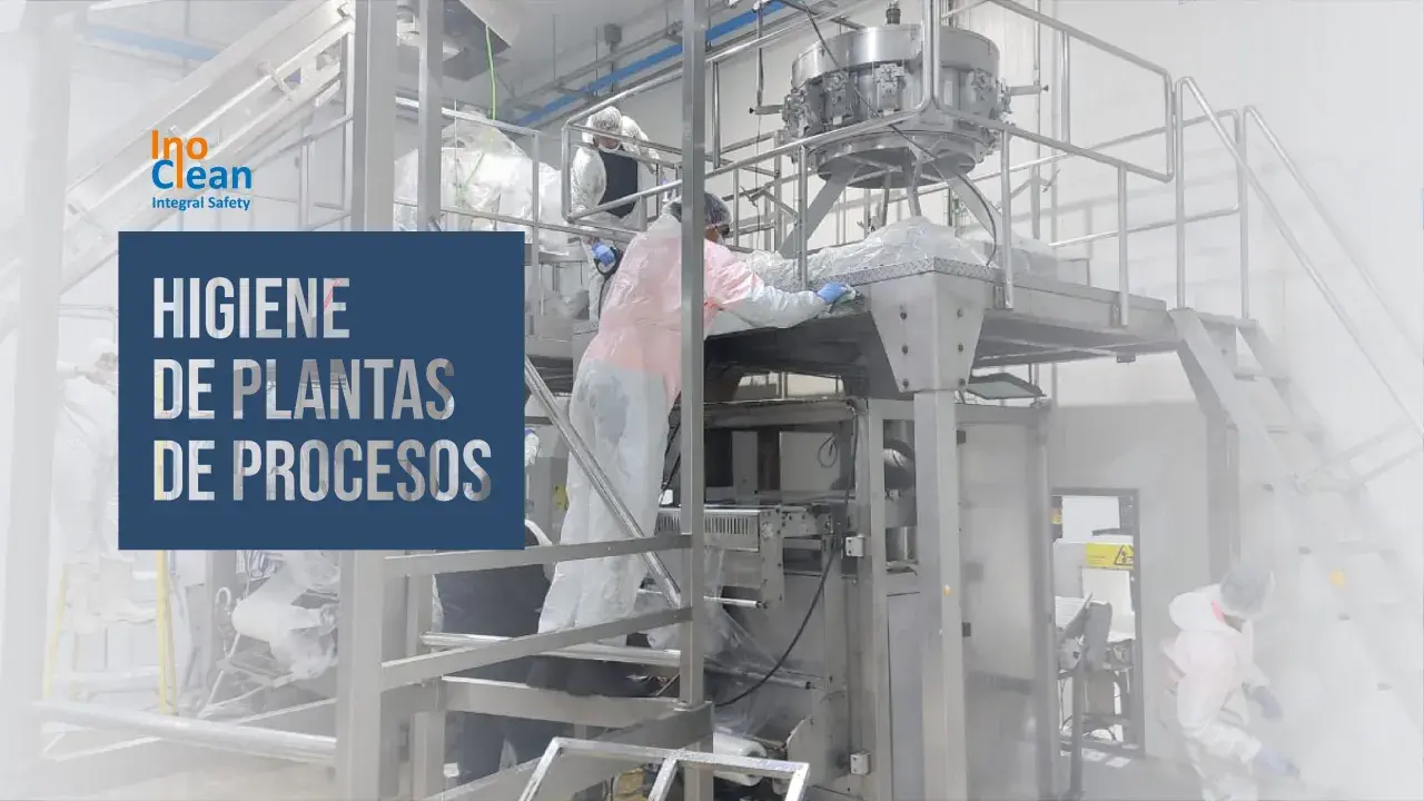 Trabajadores con trajes protectores limpian maquinaria industrial. La asepsia que es, se aplica para garantizar la higiene en plantas de procesos.