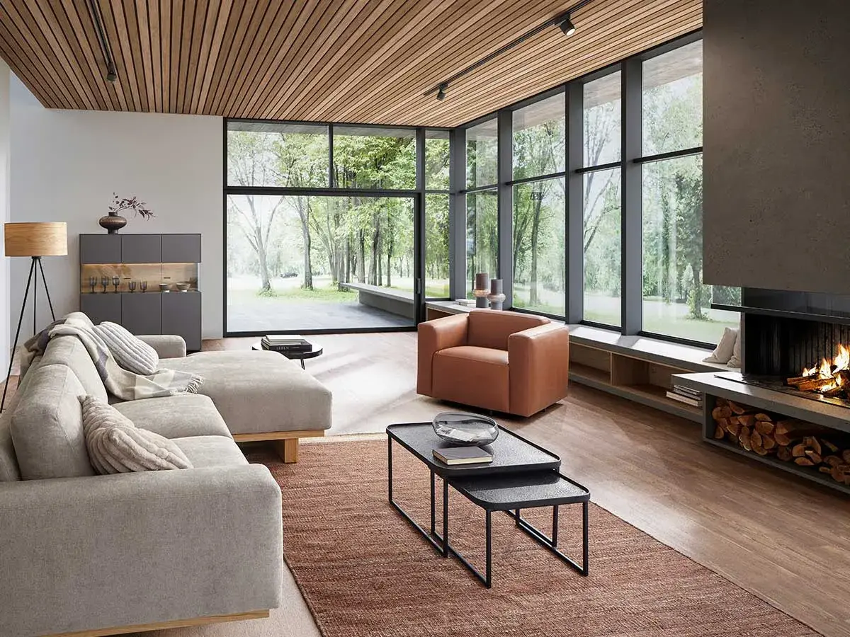 Modernes Wohnzimmer mit großem Fenster, Kamin und bequemer Couch. Tolle Einrichtungstipps für ein stilvolles Zuhause.