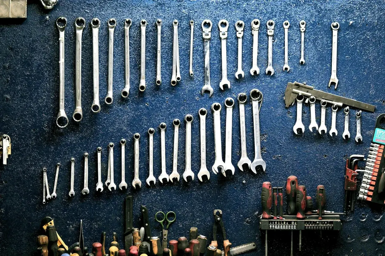 Un mur de garage bleu orné de clés à molette et d'outils divers, rappelant le droit de rétention du garage.
