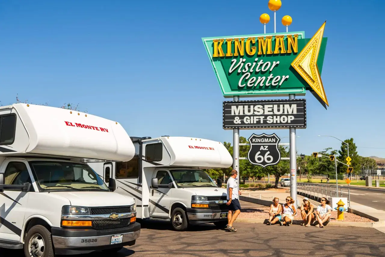 Dwa kampery El Monte RV przy znaku Kingman Visitor Center na Route 66.