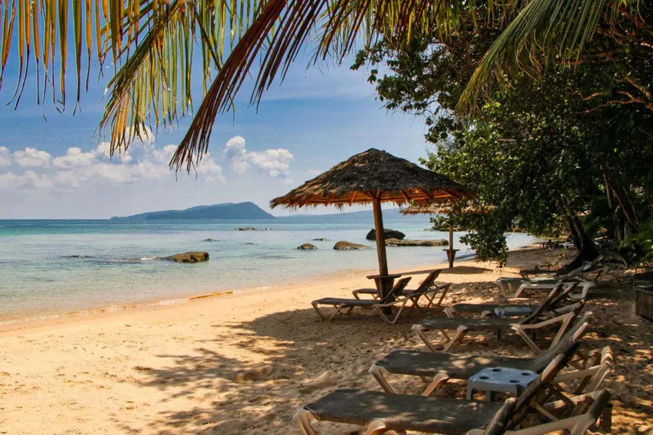 Sonniger Strand in Kambodscha, ein echter Geheimtipp. Liegestühle und Sonnenschirme laden zum Entspannen ein.