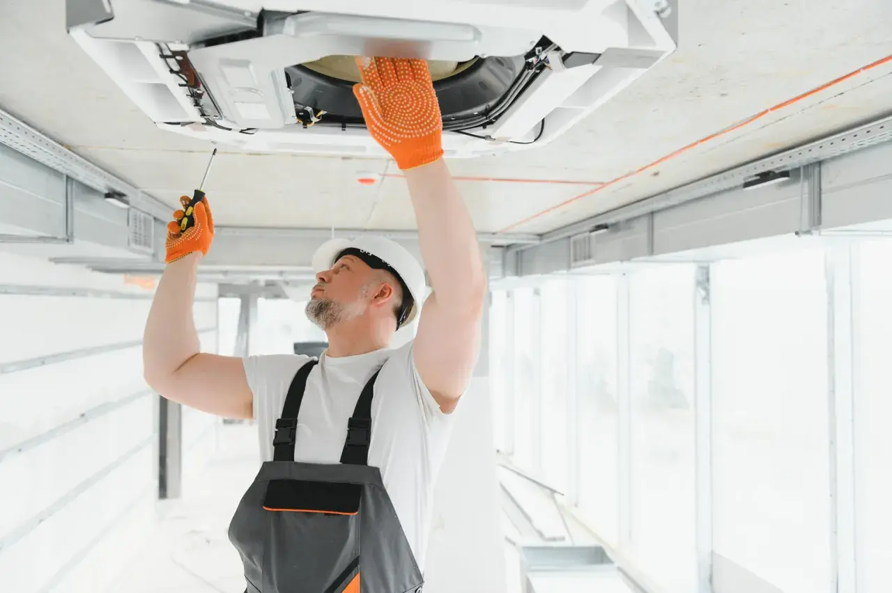 Técnico revisa unidad de aire acondicionado en el techo. Aprende como saber si un aire acondicionado tiene gas.