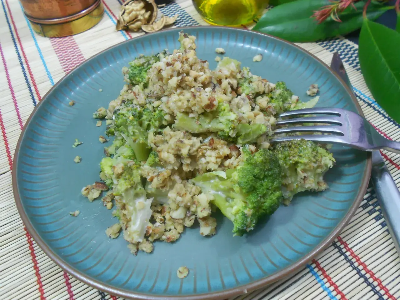 Un délicieux crumble brocolis aux noix, servi sur une assiette bleue.