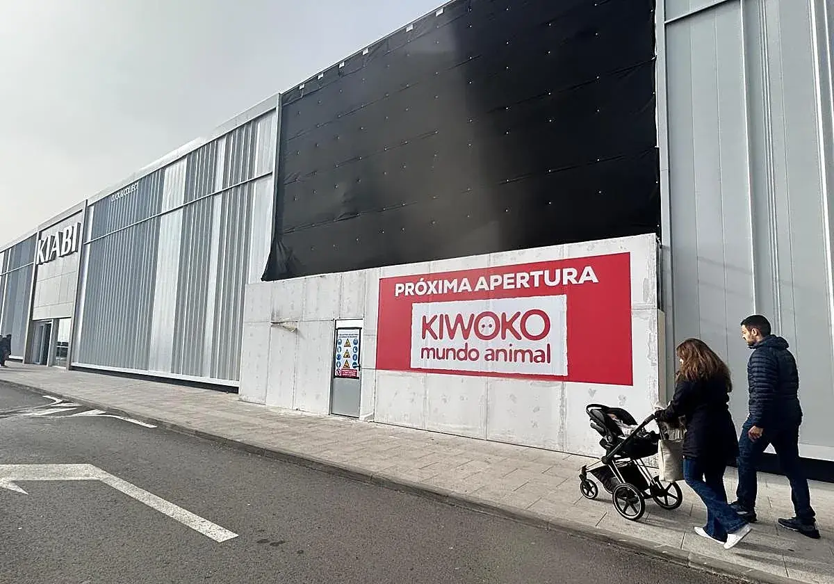 Fachada de tienda Kiwoko con anuncio de próxima apertura y gente paseando.