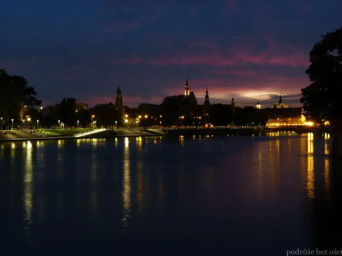 Zachód słońca nad Odrą we Wrocławiu. Idealne miejsce, by zastanowić się, co robić we Wrocławiu wieczorem, podziwiając iluminacje miasta.