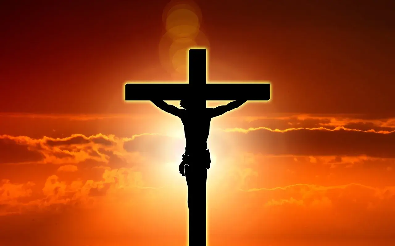 Silhuett av Jesus på korset mot en dramatisk solnedgång. Detta är en stark symbol för vad påsk betyder för många.