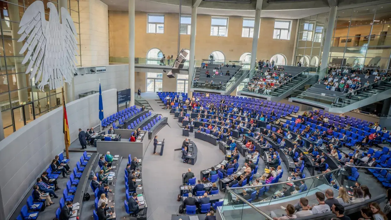 Der Bundestag im Plenum, bereit für einen Hammelsprung. Viele Abgeordnete sitzen auf ihren Plätzen, andere stehen.