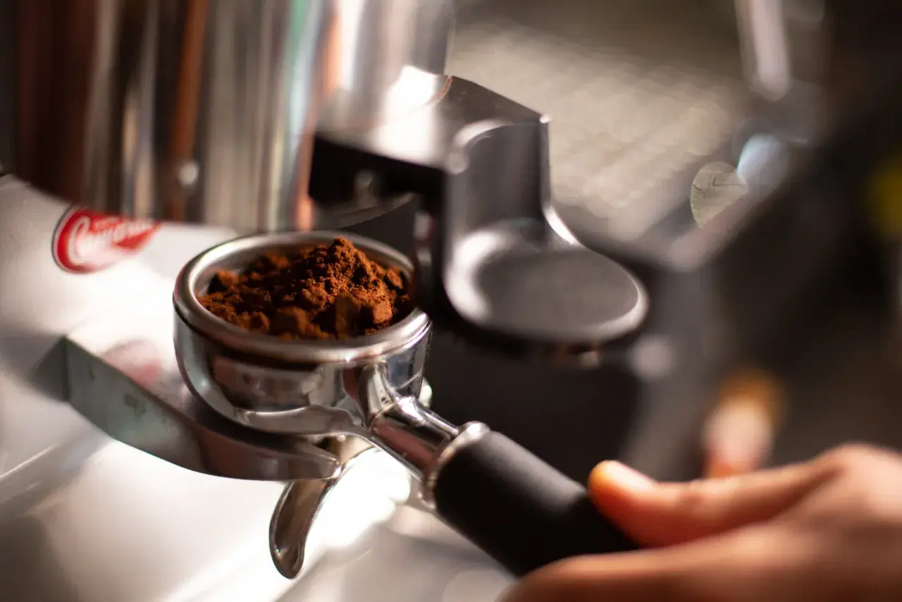 Portafiltro con macinatura caffè fine, pronto per l'estrazione. Regolare la macinatura caffè come fare per un espresso perfetto.