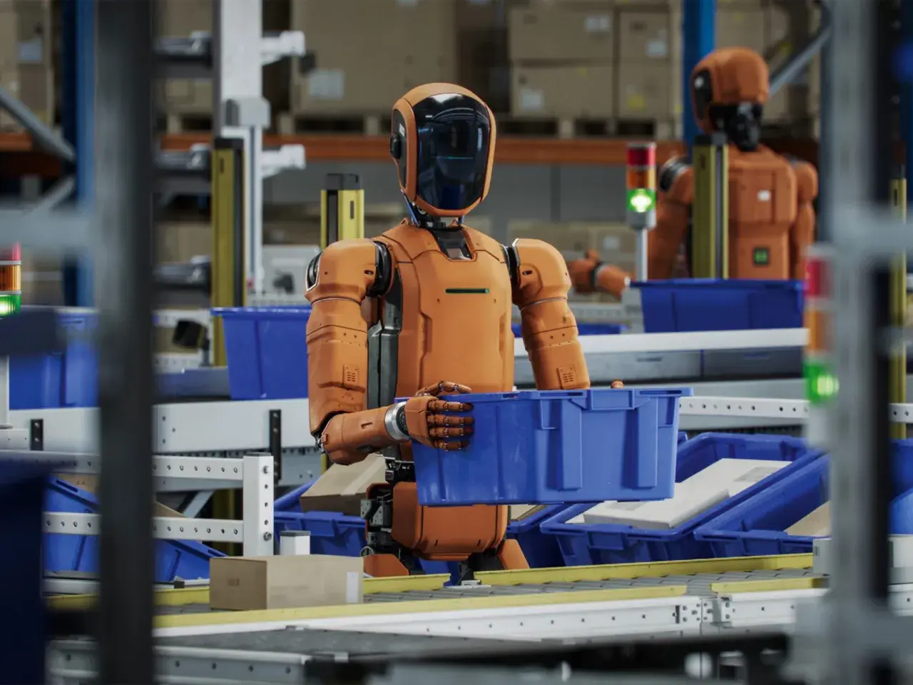 Pomarańczowy robot w magazynie przenosi niebieskie pudełko. To jest robot, który pracuje.